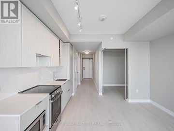 Mississauga (City Centre) condo for rent - A modern kitchen with white cabinets and a stainless steel stove.