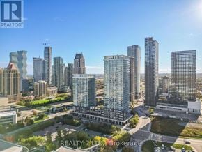 Mississauga (City Centre) condo for rent - A cityscape with a clear blue sky and buildings of various heights.