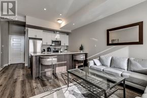 London North (North R) condo for rent - A modern kitchen with a bar stool and a glass table.