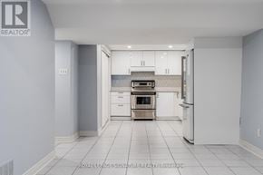 Markham (Village Green-South Unionville) apartment for rent - A white kitchen with a refrigerator, oven, and cabinets.