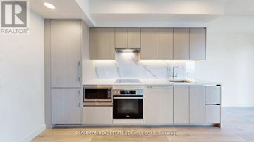 Toronto (Waterfront Communities) condo for rent - A modern kitchen with a stainless steel refrigerator and oven.
