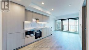 Toronto (Waterfront Communities) condo for rent - A modern kitchen with a large island and stainless steel appliances.