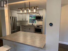 Barrie (Codrington) apartment for rent - A modern kitchen with a stainless steel refrigerator, microwave, and oven.