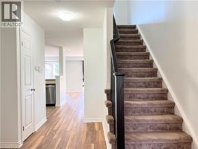 Kitchener townhouse for rent - A staircase with a carpeted runner and a black railing.