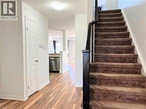 Kitchener townhouse for rent - A staircase with a carpeted runner and a black handrail.