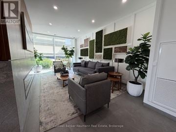 Guelph (Pineridge/Westminster Woods) condo for rent - A living room with a grey couch and a green plant.