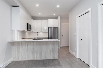 Langley apartment for rent - A modern kitchen with a stainless steel refrigerator and a wooden island.