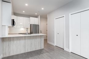 Langley apartment for rent - A modern kitchen with white cabinets and a wooden countertop.