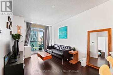 Toronto (Waterfront Communities) condo for rent - A living room with a black couch and a painting on the wall.