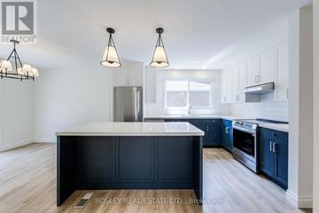 Toronto (Tam O'shanter-Sullivan) apartment for rent - A modern kitchen with dark blue cabinets and a white island.