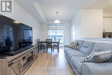 Pickering (Village East) townhouse for rent - A modern living room with a grey couch and a television.