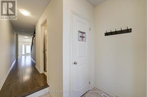 Ajax (South East) townhouse for rent - A hallway with a sign on the door and a brokerage logo on the wall.