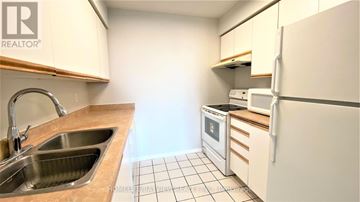 Toronto (Willowdale East) condo for rent - A kitchen with a sink, refrigerator, and oven.