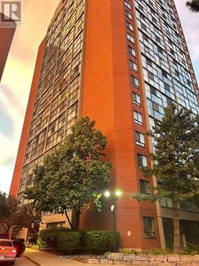 Mississauga (City Centre) condo for rent - A tall red building with a tree in front of it.