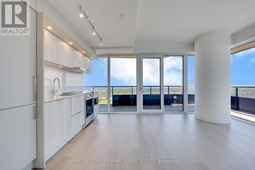 Mississauga (City Centre) condo for rent - A spacious kitchen with white cabinets and a view of the ocean.