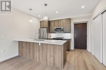 Port Colborne (Sugarloaf) condo for rent - A modern kitchen with wooden cabinets and a white countertop.