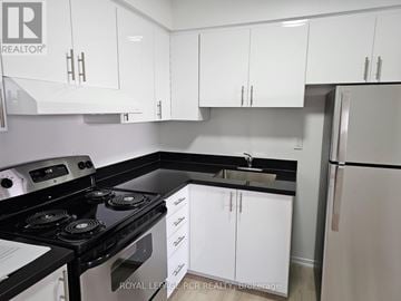 Aurora (Hills Of St Andrew) apartment for rent - A kitchen with white cabinets and black countertops.