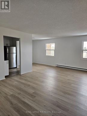 Aurora (Hills Of St Andrew) apartment for rent - A spacious room with wooden flooring and a refrigerator in the corner.