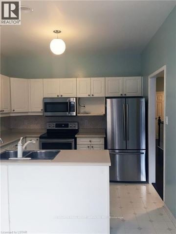 London North (North B) townhouse for rent - A kitchen with white cabinets and a stainless steel refrigerator.