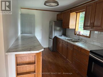 Niagara Falls (Hospital) apartment for rent - A kitchen with wooden cabinets and a marble countertop.