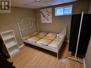 Toronto (Pleasant View) apartment for rent - A small bedroom with a white metal bed and a wooden floor.