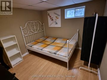 Toronto (Pleasant View) apartment for rent - A small bedroom with a white metal bed and a wooden floor.