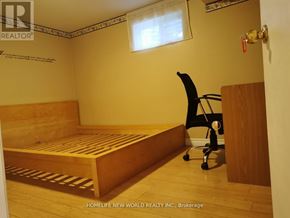 Toronto (Pleasant View) apartment for rent - A bedroom with a bed, chair, and wooden flooring.