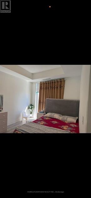 Vaughan (Concord) condo for rent - A bedroom with a bed, nightstand, and window with curtains.