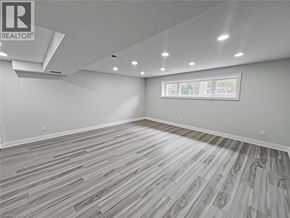 Kitchener apartment for rent - A spacious kitchen with white appliances and wooden flooring.