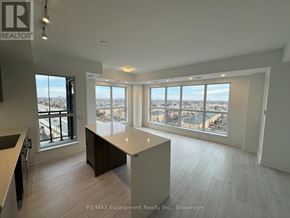 Oakville (Go Glenorchy) condo for rent - A spacious room with a large window overlooking a cityscape.