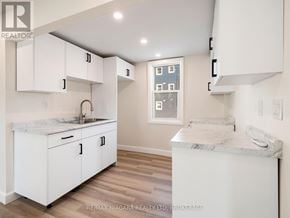 Fort Erie (Central) triplex for rent - A white kitchen with a marble counter top.