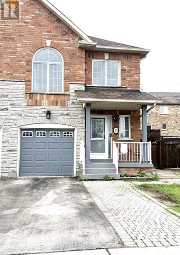 Vaughan (East Woodbridge) townhouse for rent - A house with a grey garage door and a brick wall.