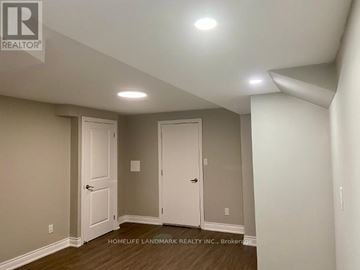 Caledon townhouse for rent - A room with two doors and a brokerage sign on the wall.
