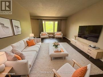 Brampton (Madoc) apartment for rent - A living room with a white couch and orange pillows.