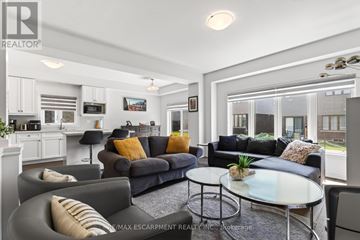Brantford apartment for rent - A living room with a grey couch and a glass table.
