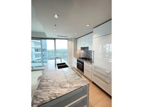 White Rock apartment for rent - A modern kitchen with a marble countertop and stainless steel appliances.