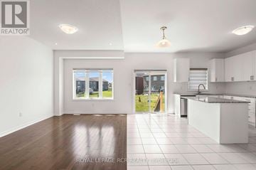 Southgate apartment for rent - A spacious kitchen and living room with white cabinets and a large window.
