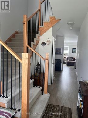 Centre Wellington (Fergus) apartment for rent - A hallway with a staircase and a couch in the background.