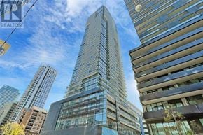 Toronto (Mount Pleasant West) condo for rent - A tall building with many windows stands in front of other buildings.