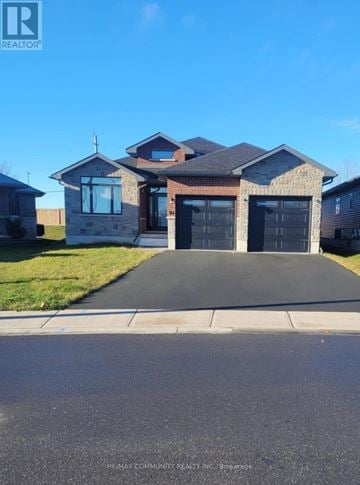 Quinte West (Murray Ward) apartment for rent - A house with a black garage door is for sale.