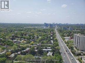 Toronto (Henry Farm) condo for rent - A cityscape with a highway in the foreground and buildings in the distance.