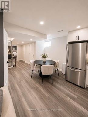 Vaughan (Kleinburg) apartment for rent - A modern kitchen with a stainless steel refrigerator and a round table with chairs.