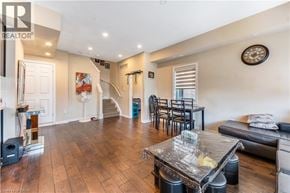 Kitchener townhouse for rent - A living room with a glass coffee table and a staircase in the background.
