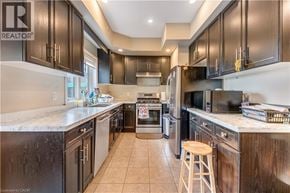 Kitchener townhouse for rent - A kitchen with dark wood cabinets and a marble countertop.