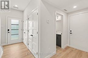 Russell apartment for rent - A white hallway with a glass door and a black trash can.