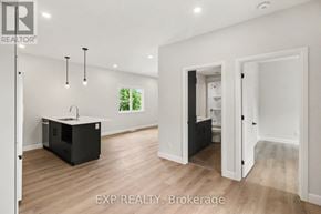 Russell apartment for rent - A real estate listing photo of a white room with wood floors and a kitchen island.