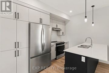 Russell apartment for rent - A modern kitchen with a stainless steel refrigerator and a white countertop.