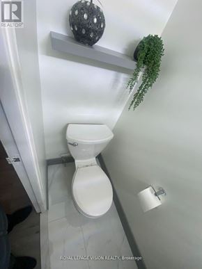 Toronto (Ionview) condo for rent - A white toilet in a bathroom with a plant on the shelf.