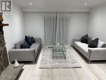 Oakville (Mo Morrison) apartment for rent - A modern living room with a glass coffee table and two grey sofas.