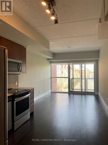 Kitchener condo for rent - A kitchen with a stove top oven and microwave.